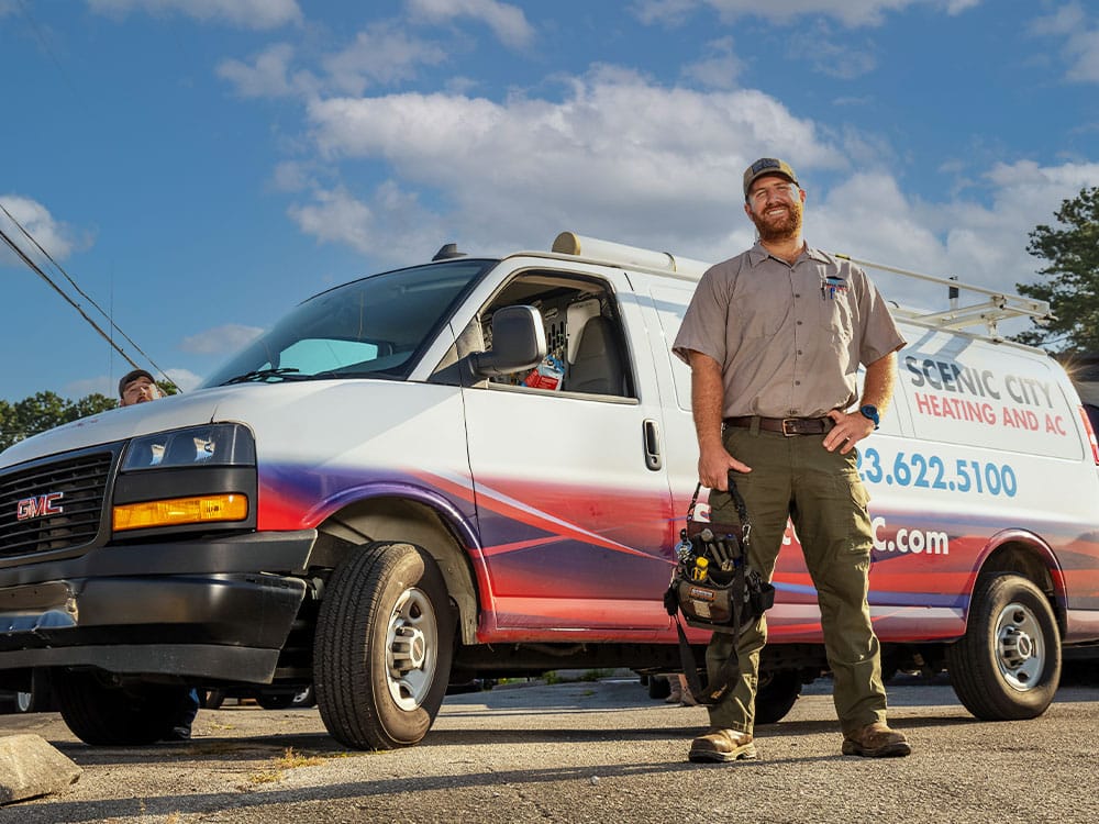 a man standing in front of a car posing for the camera